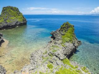 沖縄本島の恩納村の観光名所「真栄田岬」に位置する青の洞窟は地元では「クマヤーガマ」と呼ばれ、昔は台風の時や荒天時などに漁師がサバニとよばれる手こぎの船を荒波から守る場所として利用されていました。漁業が近代化してサバニの避難場所として役目を終えたこの場所は、今は沖縄で話題の人気スポットとして賑わっています。